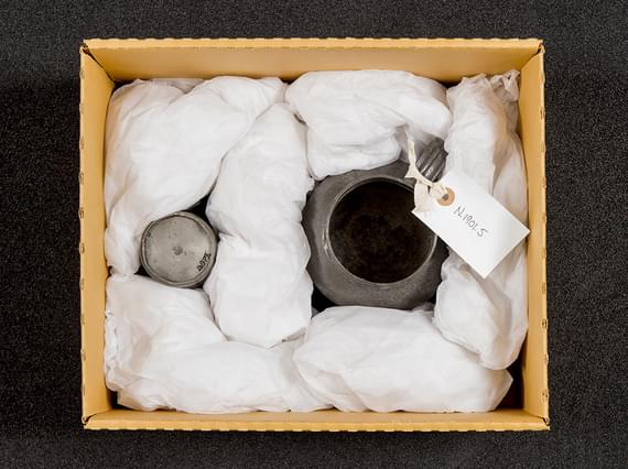 Two metal objects packed in a cardboard box.